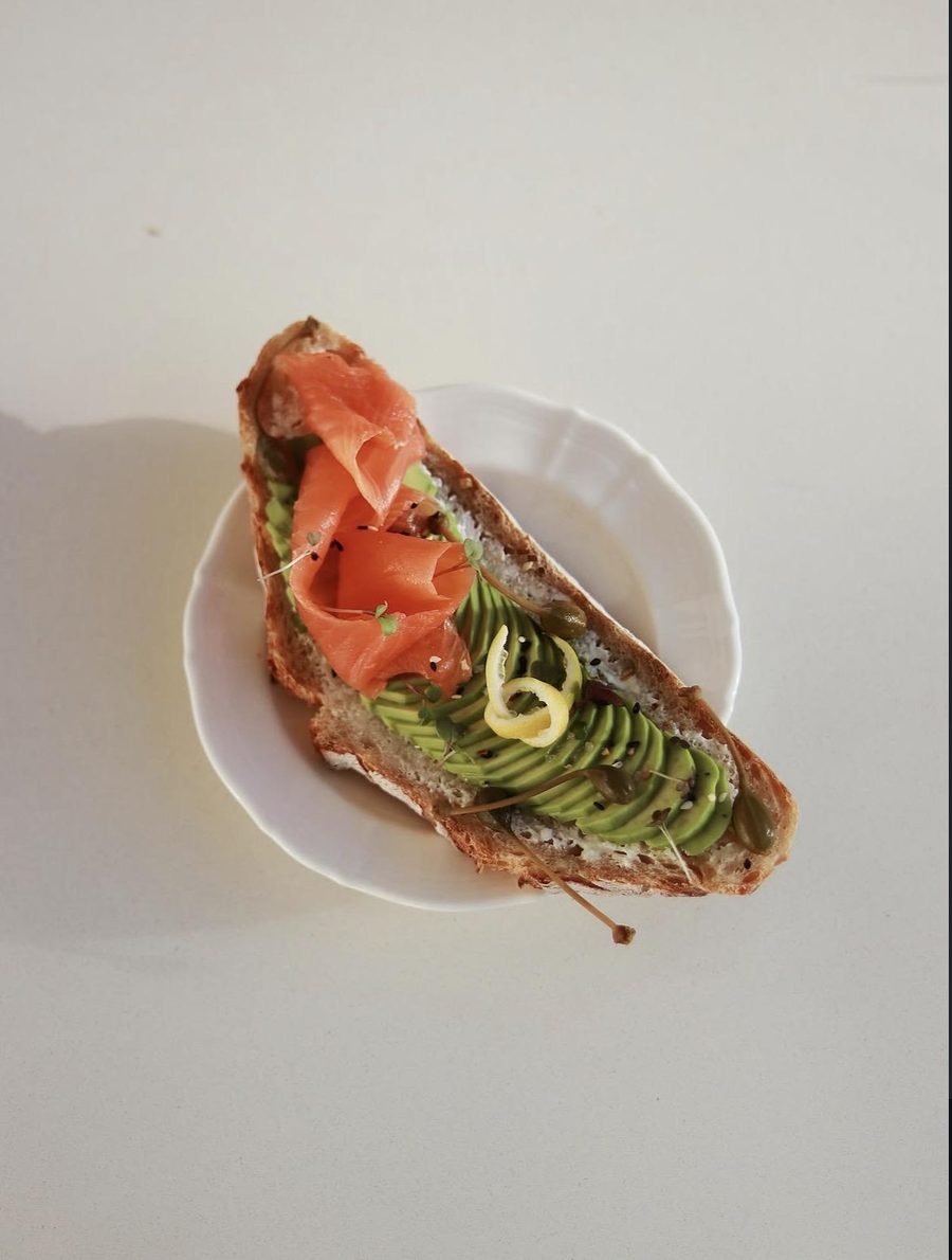 Sourdough toast topped with smoked salmon, sliced avocado and lemon