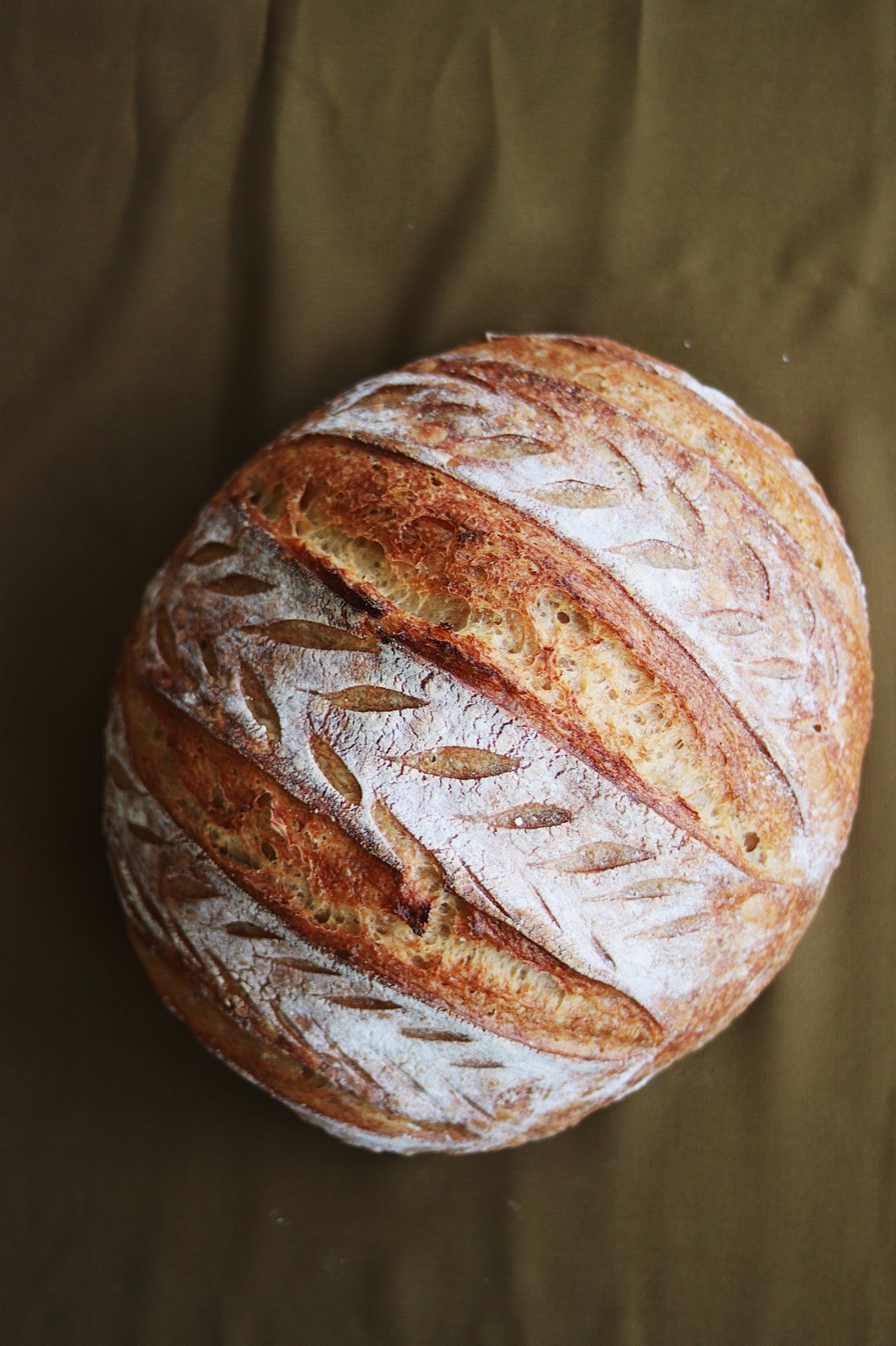 Top-down sourdough loaf with decorative scoring and a crisp crust